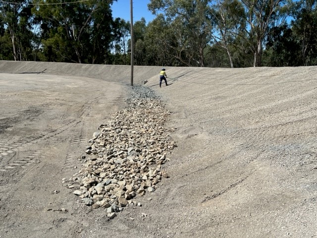 A worker is shown in the distance of a huge flood levee in Mooroopna, Victoria Australia. 