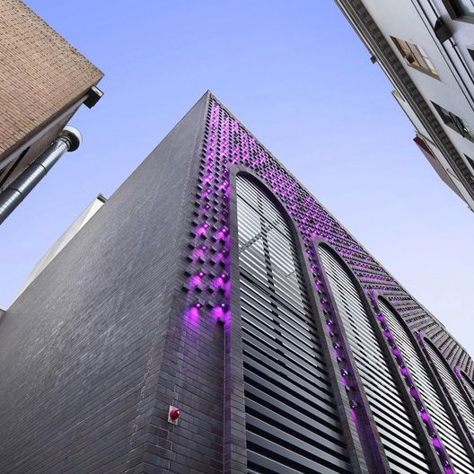 Waratah Place building external photograph with purple lighting down side of structure and arched windows
